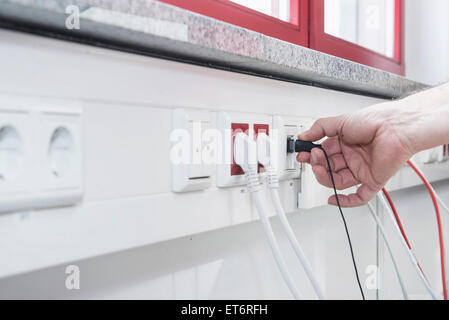 L'homme de la connexion du câble USB sur le port, Munich, Bavière, Allemagne Banque D'Images