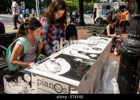 New York, NY 11 juin 2015 - Des élèves de la petite école rouge Chambre jouer 'Corps et âme' sur un piano pour chanter l'espoir conçu par Tim Farley, en peu de place rouge Banque D'Images