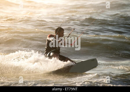 Kitesurfer en action sur un beau fonds d'embruns pendant le coucher du soleil. Banque D'Images