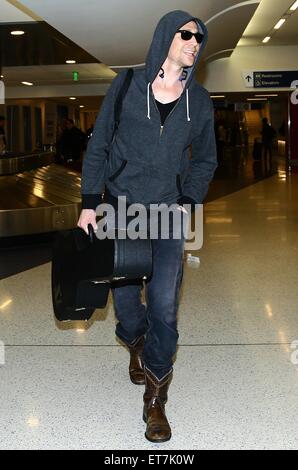 Tom Hiddleston arrive sur un vol vers l'Aéroport International de Los Angeles (LAX) portant un hoodie, Ray-Ban lunettes de soleil et bottes de cow-boy avec : Tom Hiddleston Où : Los Angeles, California, United States Quand : 18 Déc 2014 Crédit : WENN.com Banque D'Images