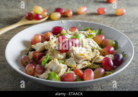 Mélanger avec la salade de poulet et les raisins sur le plat blanc Banque D'Images