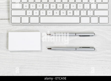 Image de clavier partielle, de la pile de cartes vierges, et de l'argent sur des stylos de bureau blanc. La mise en page en format horizontal. Banque D'Images