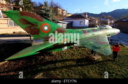 Un passant en revue la Fédération fait MiG-21 supersonic jet fighter exposées dans la cour avant d'une maison dans le village de Raduil, Bulgarie, à quelque 68 miles (110km) au sud de la capitale Sofia. Pour certains Bulgares l'achat hors service des machines militaires vendus aux enchères est quelque peu d'un passe-temps. Le MiG-21 est en ce moment toujours actif au sein de la Force aérienne bulgare. Où : Raduil, Bulgarie Quand : 20 Jan 2015 : Impact de crédit Presse Groupe/WENN.com Banque D'Images