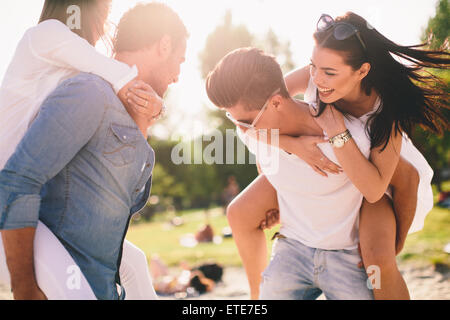 Les jeunes couples s'amusant sur la plage Banque D'Images