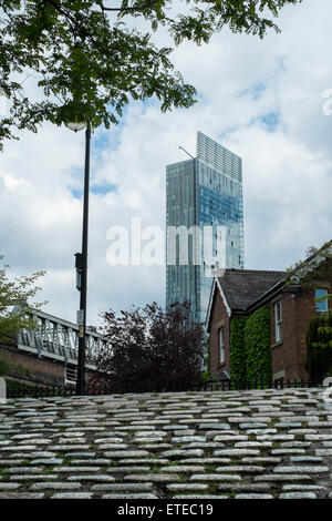 Rue Pavée avec le Manchester Hôtel Hilton moderne bullding en arrière-plan Banque D'Images