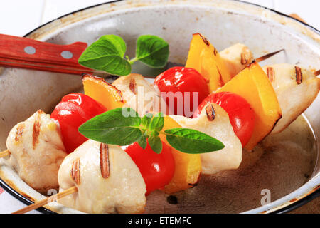 Morceaux de poulet grillé avec tomates cerises et poivron jaune en brochettes Banque D'Images