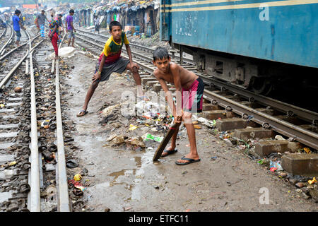 Dhaka, Bangladesh. 13 Juin, 2015. Les enfants des taudis naviguent cricket sur la voie ferrée entouré par des maisons de fortune dans la région de Dhaka, Bangladesh. Le 13 juin 2015 dans la capitale animée du Bangladesh Dhaka, l'espace est limité. Des milliers de maisons de fortune sont construites chaque semaine dans des bidonvilles, certains d'entre eux juste à côté de la voie ferrée. Cette histoire est au sujet d'eux, ces gens qui vivent à risque en regard de cette voie ferrée. Mamunur Rashid/crédit : Alamy Live News Banque D'Images