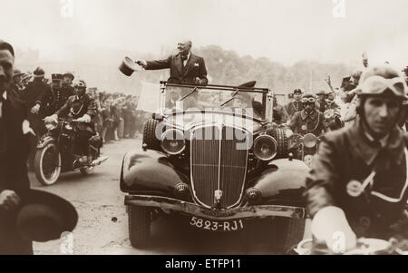 Winston Churchill en agitant son nouveau chapeau gris tout en étant entraîné par la foule accueillante à Metz, en France, où le premier ministre britannique a été invité d'honneur de la ville forteresse Bastille Day (14 juillet) Fête. Banque D'Images