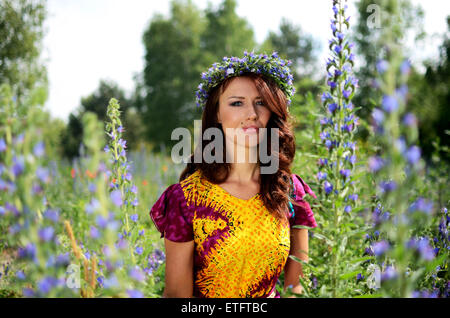 Belle fille de la Pologne avec couronne faite de fleurs. Portrait de modèle féminin entouré de bruyères. Banque D'Images