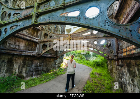 Une femme marche sous la voûte d'un viaduc de l'époque victorienne Banque D'Images