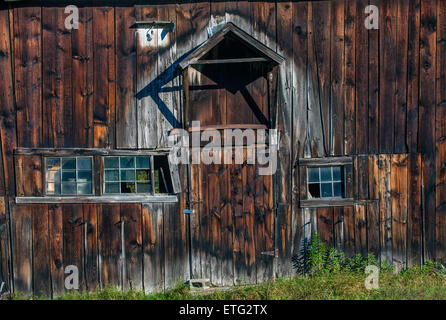 Étude de la texture old weathered barn mur en bois gris avec des traces de pluie et de vieilles fenêtres. Banque D'Images