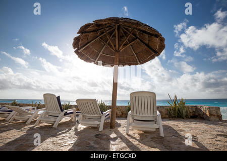 Plage des Caraïbes avec l'herbe de parasols et lits. Locations de concept Banque D'Images