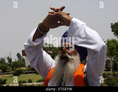 Lahore. 13 Juin, 2015. Un pèlerin Sikh indiens prie après avoir traversé la frontière Wagha poster dans l'est de Lahore au Pakistan le 13 juin 2015. Des centaines de pèlerins sikhs sont arrivés au Pakistan le samedi à participer à des cérémonies marquant la mort de la cinquième gourou sikh, Arjan Dev Ji. © Jamil Ahmed/Xinhua/Alamy Live News Banque D'Images