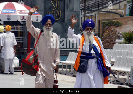 Lahore. 13 Juin, 2015. Vague de pèlerins Sikhs Indiens alors qu'ils traversent la frontière Wagha poster dans l'est de Lahore au Pakistan le 13 juin 2015. Des centaines de pèlerins sikhs sont arrivés au Pakistan le samedi à participer à des cérémonies marquant la mort de la cinquième gourou sikh, Arjan Dev Ji. © Jamil Ahmed/Xinhua/Alamy Live News Banque D'Images