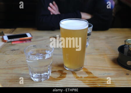 Une pinte de bière sur une table en bois dans la région de Camden Banque D'Images