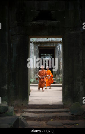 SIEM REAP, Cambodge - 30 octobre 2014 : Paire de novice moines bouddhistes en robe safran marche à travers l'architecture des temples d'Angkor. Banque D'Images
