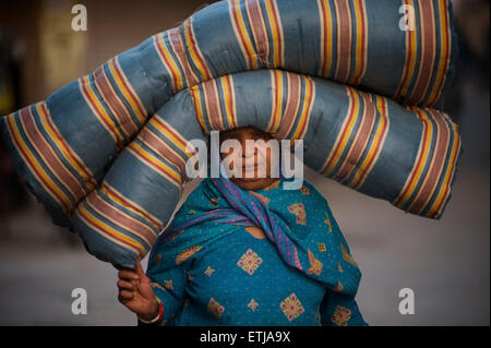 Femme indienne en sari portant un matelas plié sur sa tête, Jodhpur, Rajasthan, India Banque D'Images