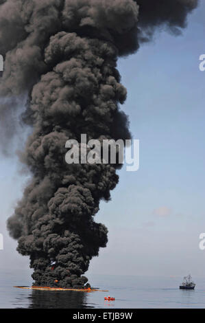 Les nuages sombres comme le ciel des équipages nettoyer un brûlage contrôlé d'huile recueillie à partir de la surface du golfe du Mexique à la suite de la marée noire Deepwater Horizon de BP la catastrophe que les efforts déployés pour contenir et nettoyer les millions de gallons d'équipage continuent le 6 mai 2010 dans le golfe du Mexique. Banque D'Images