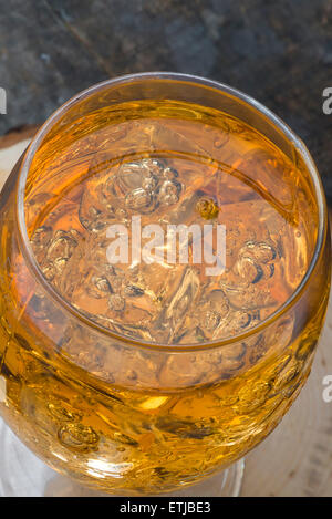 Verre de cidre rempli de cubes de glace et les pommes sur la table en bois Banque D'Images