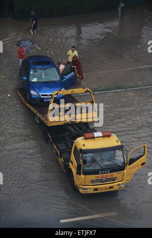 (150614) --YICHUN, 14 juin 2015 (Xinhua) -- Une voiture est remorquée par un camion de remorquage dans la ville de Yichun, dans la province de Jiangxi en Chine centrale, le 14 juin 2015. Le Centre météorologique national (CMN) a émis une alerte jaune pour les orages dans le sud de la Chine le dimanche. De fortes pluies jusqu'à 180 mm balaiera parties de Hunan, Jiangxi, Zhejiang, Hubei et Anhui provinces ainsi que la région autonome Zhuang du Guangxi à partir de dimanche matin, la prévision de la CNG. Il a également mis en garde contre de possibles orages et tempêtes dans ces domaines. (Xinhua/Zou Haibin) (yxb) Banque D'Images