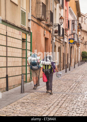 Back packers marche dans une rue de Logroño, La Rioja, Espagne, vers une coquille Saint-Jacques signe, qui est la cote officielle pour... Banque D'Images