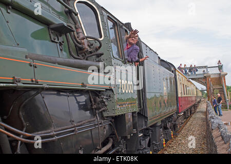 Dawlish Warren, au Royaume-Uni. 14 Juin, 2015. Se pencher à l'équipage de la fenêtre et vague comme Britannia Torbay,train à vapeur Express passe par Dawlish Warren. Credit : Keith Larby/Alamy Live News Banque D'Images