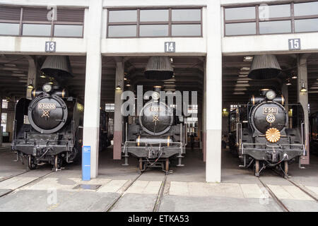 Japon, Kyoto, Musée Des Locomotives À Vapeur Umekoji. Trois locomotives faisant face au spectateur dans la locomotive en forme de ventilateur dans des baies séparées. Banque D'Images