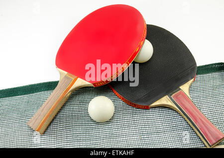 Deux raquettes de tennis de table l'une sur l'autre et d'un vieux white net. Une palette est rouge et l'autre est noir Banque D'Images