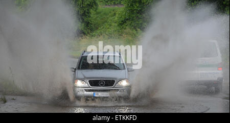 Denzlingen, Allemagne. 14 Juin, 2015. Une voiture fait une énorme splash comme il fait son chemin à travers un passage souterrain inondé à Denzlingen, Allemagne, 14 juin 2015. Une tempête a provoqué d'importantes inondations dans plusieurs endroits de Denzlingen, le service des incendies a dit. Photo : PATRICK SEEGER/dpa/Alamy Live News Banque D'Images