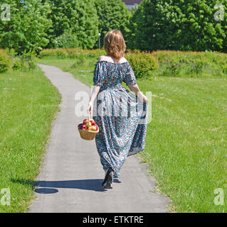 Une femme adulte avec un panier de fruits dans le parc Banque D'Images