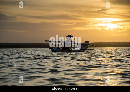 Man working on his seaplane entouré d'eau au coucher du soleil dans le sud-est, USA Banque D'Images