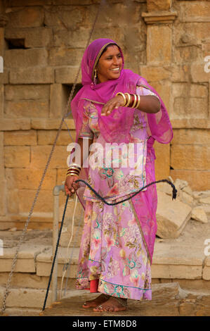 Femme du Rajasthan la collecte de l'eau d'un puits à Amar Sagar, Lodurva nr, Jaisalmer, Rajasthan, India Banque D'Images