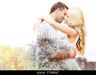 Heureux couple hugging sur cherry blossom Banque D'Images