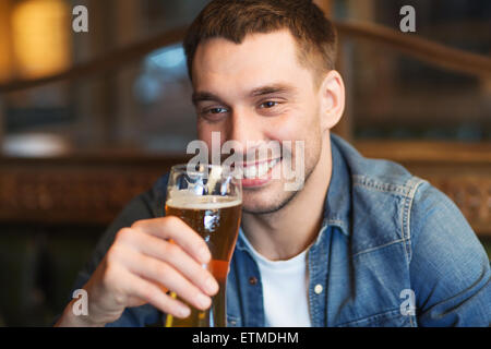 Homme heureux de boire une bière au bar ou au pub Banque D'Images