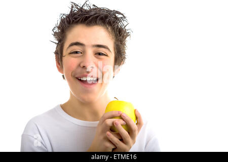 Un beau garçon de race blanche portant une chemise blanche à manches longues est titulaire d'un yellow apple avec les deux mains Banque D'Images