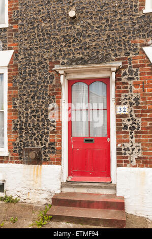 Entrée victorienne de Kentish flint knapped mur de pierre en terrasse contraste avec la porte rouge et étapes Banque D'Images