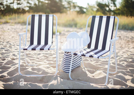 Deux salons de plage avec sac de plage et chapeau blanc Banque D'Images