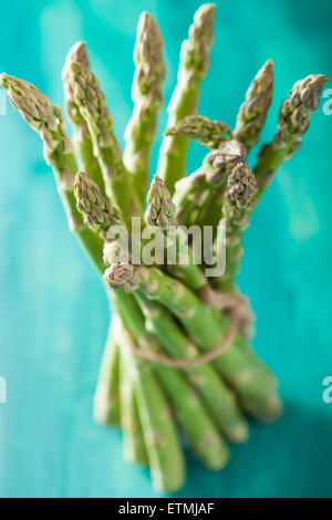 Bande d'asperges fraîches sur fond bleu turquoise Banque D'Images