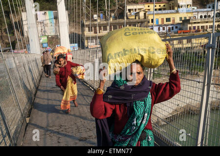 Sac de transport pour les femmes sur la tête sur le pont de Ram jula, Rishikesh. Banque D'Images