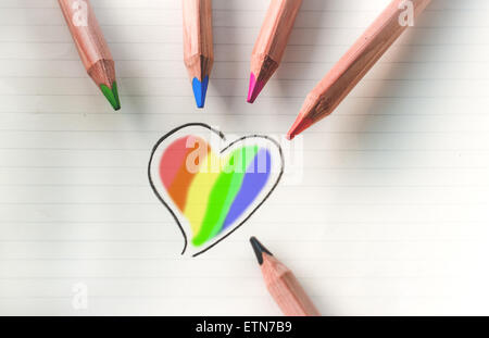 Crayons de couleur et dessin d'un coeur multicolore Banque D'Images