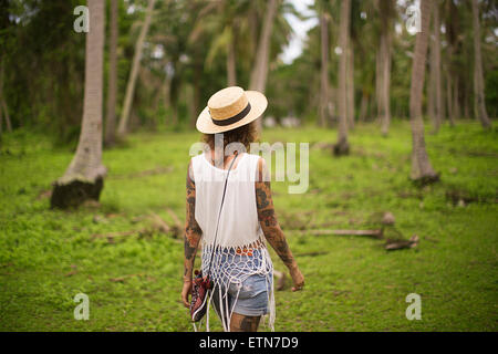 Vue arrière d'une femme marchant dans un jardin tropical, la Thaïlande Banque D'Images