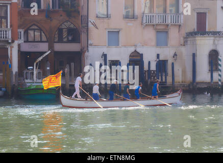 Soleil voilé sur un bateau ramé par six hommes et battant pavillon d'un Vénitien lion ailé voyageant le long du grand canal Venise Banque D'Images