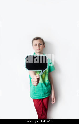 Boy holding out a bulle pensée board Banque D'Images