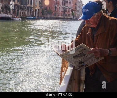 La lecture des passagers journal italien 'Il Gazzettino" sur un vaporatto sur le Grand Canal Venise Vénétie Italie Europe Banque D'Images