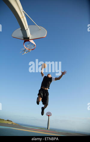 Jeune homme jouant au basket-ball dans un parc, Los Angeles, Californie, USA
