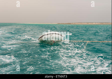 Un petit canot pneumatique motor yacht remorqué sur une mer tropicale Banque D'Images