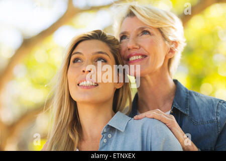 Smiling senior mother and young daughter looking up Banque D'Images