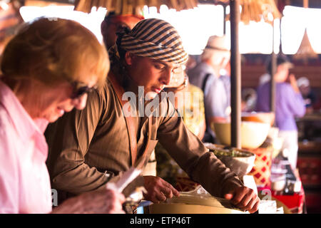 Garçon arabe bédouine préparant et servant moyen-orientaux aux touristes à camp arabe Wadi Rum Jordanie Moyen Orient. Banque D'Images