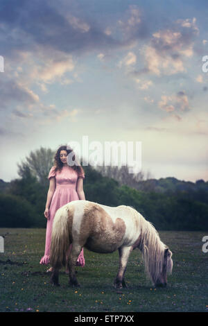 Une femme avec un poney sur un paddock Banque D'Images