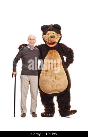 Full Length portrait of a senior man hugging et posant avec un mec dans un costume d'ours et regardant la caméra Banque D'Images